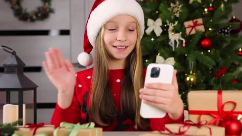 Girl communicates via video call using smartphone in christmas interior Stock Footage 165688413