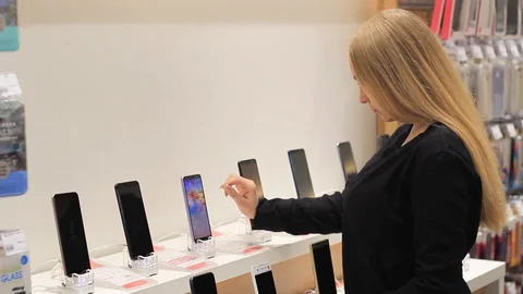The girl is considering a mobile device in the store Stock Footage 103859925