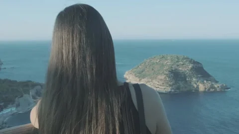 Girl contemplating a beautiful island from a viewpoint Stock Footage