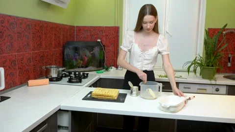 The girl is cooking in the kitchen. She is making cream for the cake. Stock Footage 281483486