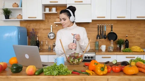 Girl Cooking In Kitchen While Using Laptop Looking For Recipe. Видео 111409624