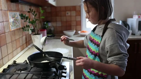 A girl cooks pancakes in the kitchen Stock Footage