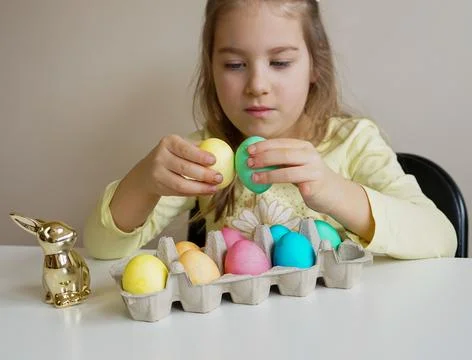Girl Cracking Easter Eggs in a Fun Holiday Tradition Stock Photos