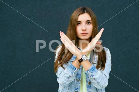 A girl crossed her arms, a sign of prohibition, a smile Stock Photos