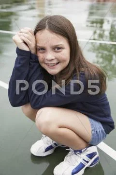 Girl crouching on playground Stock Photos