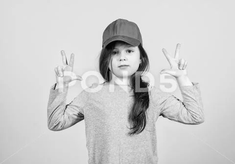 Girl cute child wear cap or snapback hat beige background. Little girl wearing Stock Photos