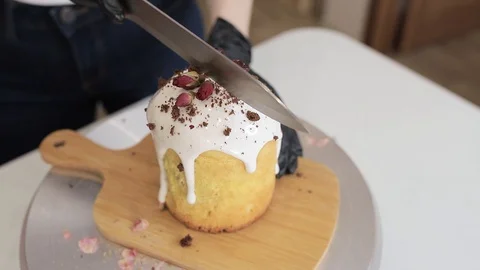 Girl cuts Easter baking with a knife on a wooden board Stock Footage 128567096
