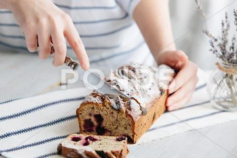 Girl cuts homemade banana bread with slices Stock Photos