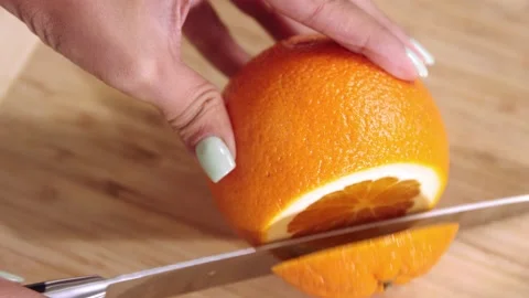 Girl cuts an orange 스톡 동영상 169811722