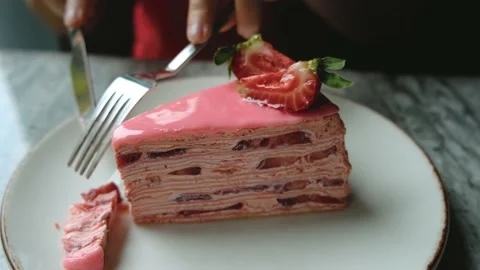A girl cuts a piece of strawberry cake with a knife Stock Footage 196286653