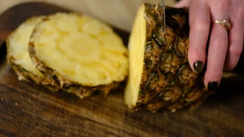 Girl cuts pineapple in the kitchen Stock-Footage 127290103