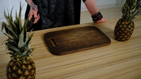 Girl cuts pineapple in the kitchen 库存影片 127290227