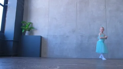 A girl dancer in a ballet school is learning to dance. Little ballerina in Stock Footage 240975566
