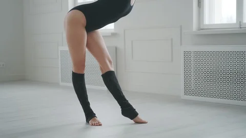 Girl dancer does stretching in a bright studio. young woman in a black bodysuit Stockbeeldmateriaal 121414005