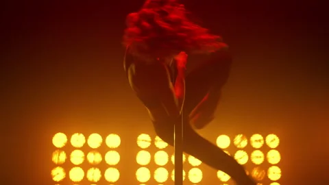 Girl dancer performing acrobatic elements pole dance in nightclub stage closeup. Stock Footage 182832170
