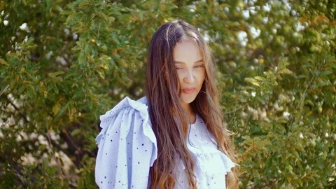 The girl dances in front of the camera on a background of green foliage of trees Stock Footage 78712492
