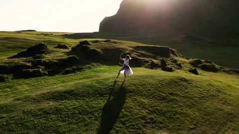 Girl dancing on the grass, view from a drone Stock Footage 261837664