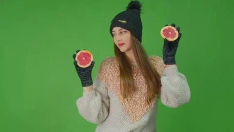 A girl is dancing looking at the grapefruit witch she holds in her hands. Stock Footage 157937693