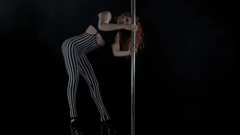 The girl is dancing Pole Dance on dark backgroun, in studio with smoke Stock Footage 76501769