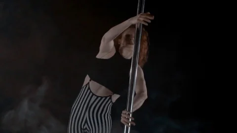 The girl is dancing Pole Dance on dark backgroun, in studio with smoke Stock Footage 76502286
