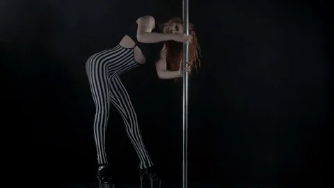 The girl is dancing Pole Dance on dark backgroun, in studio with smoke Stock Footage 76503942