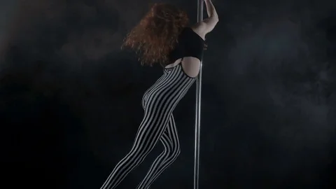 The girl is dancing Pole Dance on dark backgroun, in studio with smoke Stock Footage 76503980
