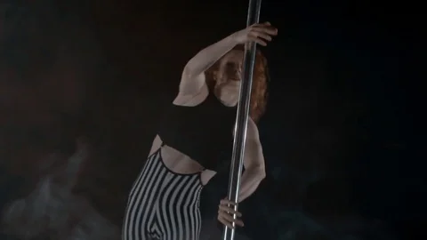 The girl is dancing Pole Dance on dark backgroun, in studio with smoke Stock Footage 76504069
