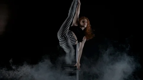 The girl is dancing Pole Dance on dark backgroun, in studio with smoke Stock Footage 76504089