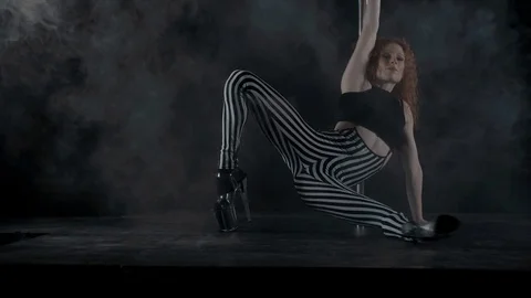The girl is dancing Pole Dance on dark backgroun, in studio with smoke Stock Footage 76504125