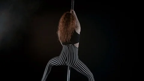 The girl is dancing Pole Dance on dark backgroun, in studio with smoke Stock Footage 76504148