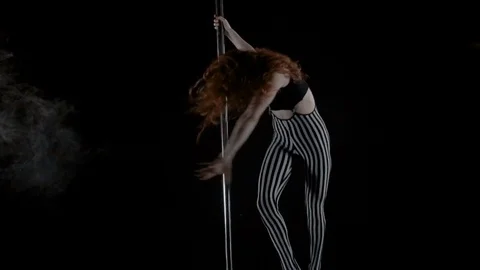 The girl is dancing Pole Dance on dark backgroun, in studio with smoke Stock Footage 76504203