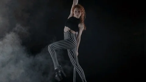 The girl is dancing Pole Dance on dark backgroun, in studio with smoke Stock Footage 76504204