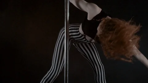 The girl is dancing Pole Dance on dark backgroun, in studio with smoke Stock Footage 76504242