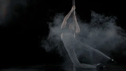 The girl is dancing Pole Dance on dark backgroun, in studio with smoke Stock Footage 76504283
