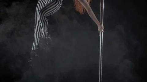 The girl is dancing Pole Dance on dark backgroun, in studio with smoke Stock Footage 76504311