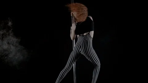 The girl is dancing Pole Dance on dark backgroun, in studio with smoke Stock Footage 76504490