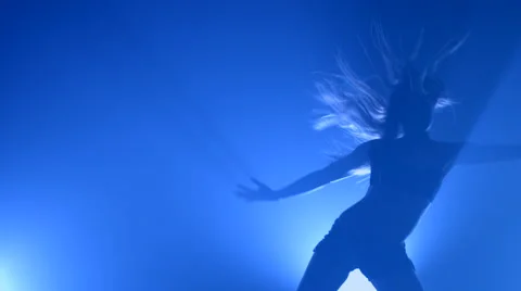 Girl dancing in a smoke on a blue background Stock Footage 63065249