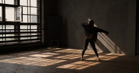 Girl dancing in studio with large windows and beautiful sunlight Stock Footage 116496428