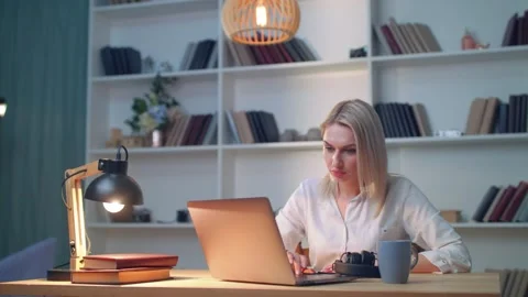 Girl dancing while sitting at table and listening to song from laptop Stock Footage 135320465