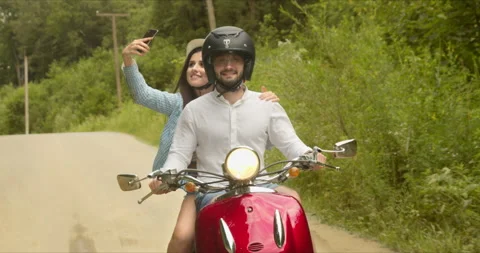 The girl decided to take a selfie while riding a scooter with her lover 動画素材 151323836
