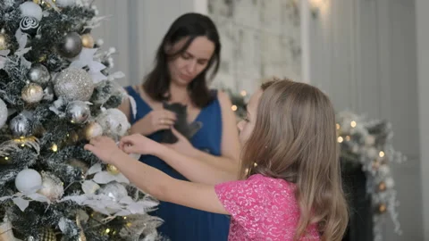 Girl Decorates Xmas Tree while Mother Pets Kitten Vídeo Stock 165029673