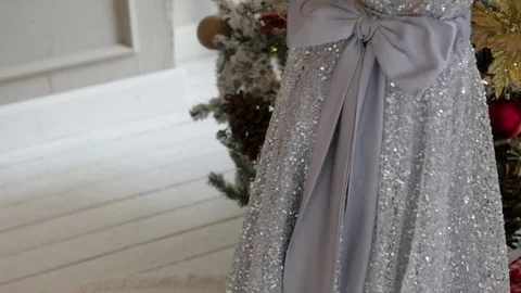 The girl is decorating a Christmas tree in a flattering dress with a train Stock Footage 85152096
