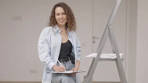 Girl designer keeps documents while standing at her workplace Stock Footage 289134219