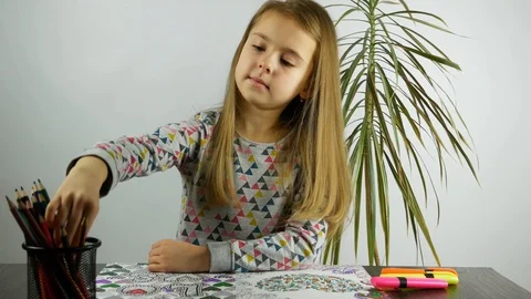 A girl at the desk coloring the notebook. Stock-Footage 86532760