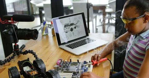 A girl develops technical skills through a hands-on STEM electronics project. Fotos de archivo