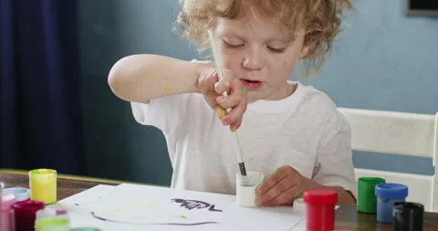 Girl dips brush in paint adding new colors to drawing Video stock 277562602