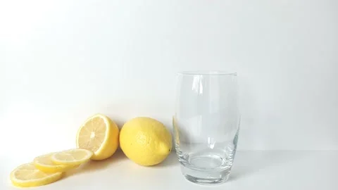 Girl dips a pill with vitamin C in a glass of water. Nearby are lemons Stock Footage