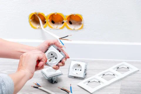 The girl disassembles the outlet before installing it. Stock Photos