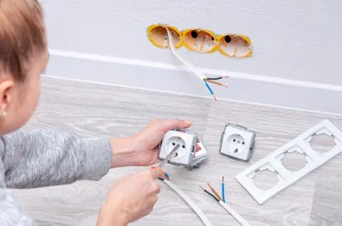 The girl disassembles the outlet before installing it. Stock Photos