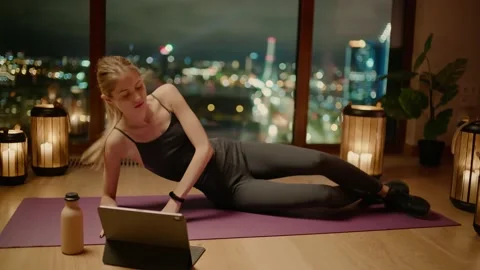 Girl Do Exercise Watching Tutorial on Tablet 動画素材 144047494